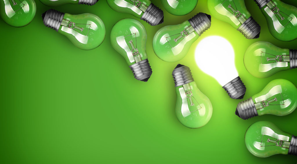 Idea concept with light bulbs on green background
